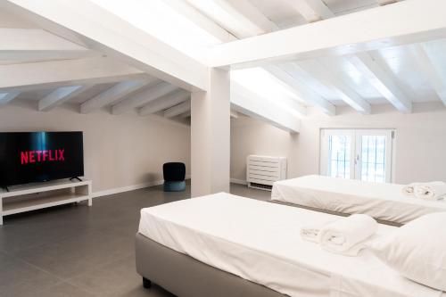 デセンツァーノ・デル・ガルダにあるResidence Il Giglioのベッド2台と薄型テレビ付きのベッドルーム