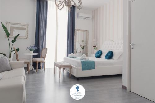 un soggiorno bianco con letto e tavolo di Palazzo Chiatamone a Napoli