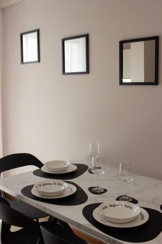 a table with two plates and two wine glasses at My Fiorella Apartment in Terni