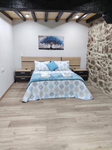 a bedroom with a bed and a stone wall at La Molnera in La Molina