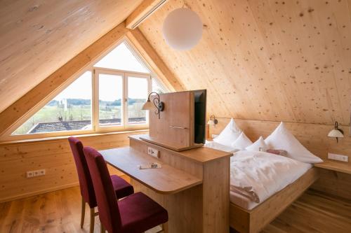 ein Schlafzimmer mit einem Schreibtisch und einem Bett im Dachgeschoss in der Unterkunft Hotel Gasthof zur Post in Wolfegg