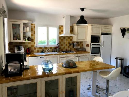 une cuisine avec des armoires blanches et un comptoir en bois dans l'établissement Maison Collobrières, à Collobrières