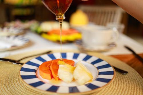 Un plato de fruta con salsa en una mesa. en Pousada Hibisco, en Trancoso