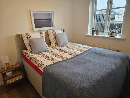 a bed sitting in a bedroom with a window at Lejlighed B med dejlig privat gårdhave på Thurø Kæledyr er IKKE gratis og skal tilføjes in Svendborg