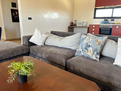 ein Wohnzimmer mit Sofa und Tisch in der Unterkunft Villa l'odyssée in Marrakesch