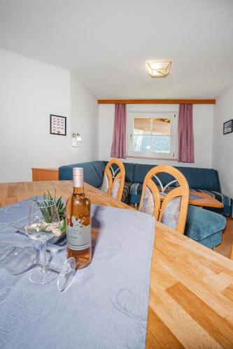 a bottle of whisky on a table in a living room at Appartements Mary inklusive Tauern-Spa Kaprun in Kaprun