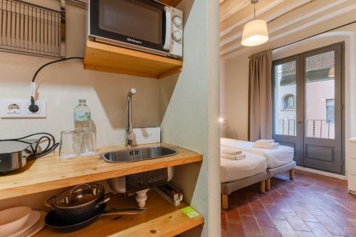 una cocina con fregadero y microondas en Flateli Ballesteries, en Girona