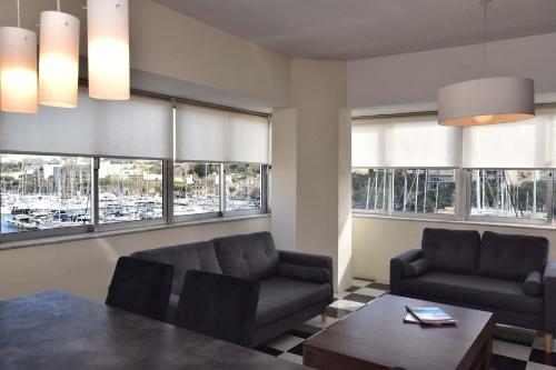un soggiorno con tavolo, sedie e finestre di Bright and Central 2 Bedroom with Harbour view a Msida