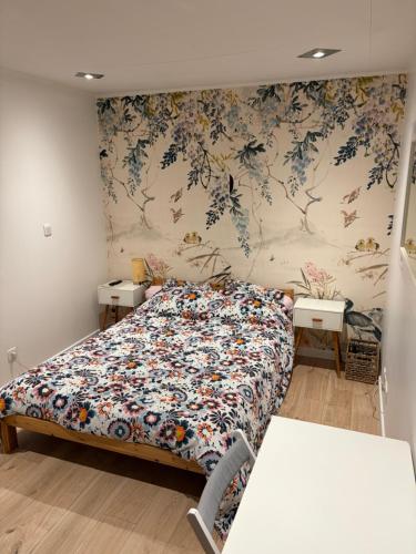 a bedroom with a bed with a floral wallpaper at Coin de paradis à Grenoble in Poisat