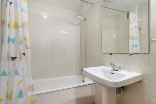 a bathroom with a sink and a mirror and a tub at Casa En El Centro De Barbate in Barbate