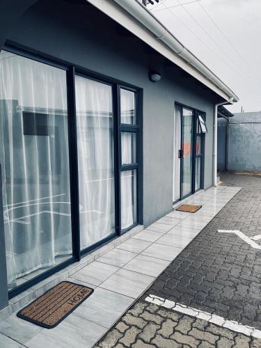 马塞卢Blue Horizon Bed and Breakfast的有大玻璃窗和露台的建筑