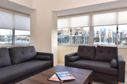 a living room with two couches and a coffee table at Sea view Spacious 2 bedroom central apartment in Msida