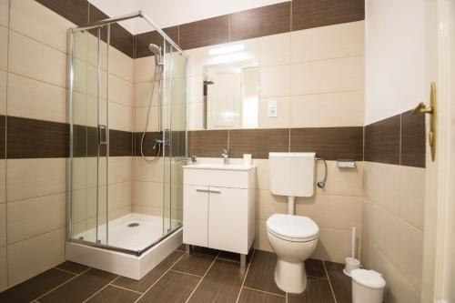 a bathroom with a toilet and a glass shower at Concept Apartments in Budapest