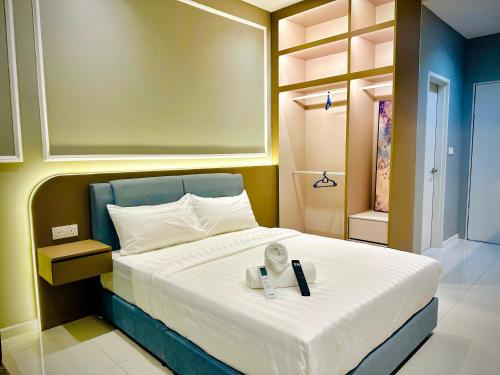 a bedroom with a bed with a remote control on it at Majestic Residence KLCC By Homestay in Kuala Lumpur