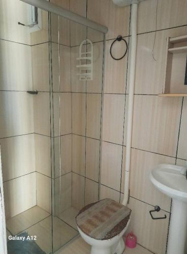 a bathroom with a shower with a toilet and a sink at Dúplex Próximo da Praia Tramandai in Tramandaí