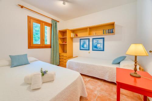 a bedroom with two beds and a red desk at Ideal Property Mallorca - Can Besso in Alcanada
