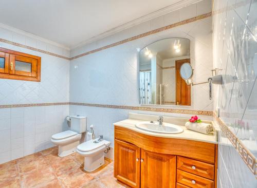 a bathroom with a sink and a toilet and a mirror at Ideal Property Mallorca - Can Besso in Alcanada