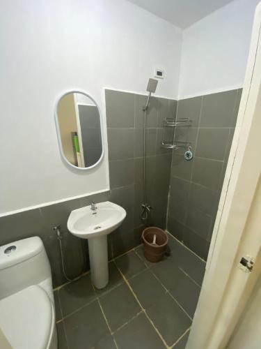 a bathroom with a toilet and a sink and a mirror at As Thetic Transient in San Pablo