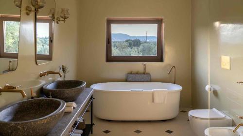 a bathroom with two sinks and a large bath tub at Masseria San Lorenzo Resort in Fasano