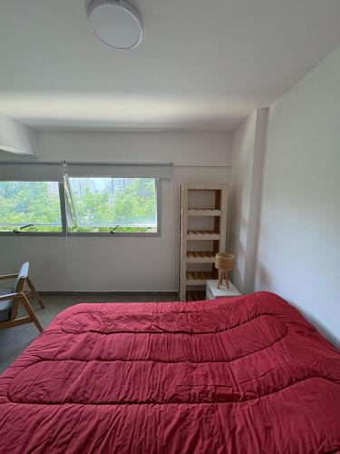 拉普拉塔Departamento monoambiente La plata, Zona centro的卧室设有红色大床和窗户。