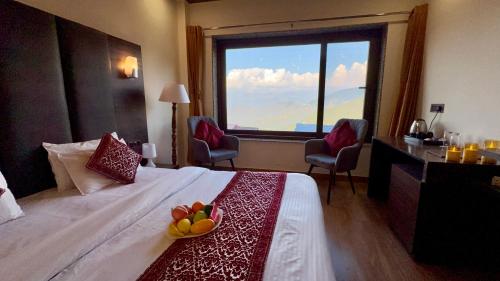 um quarto de hotel com uma cama e uma janela grande em The Zen Villa em Dalhousie