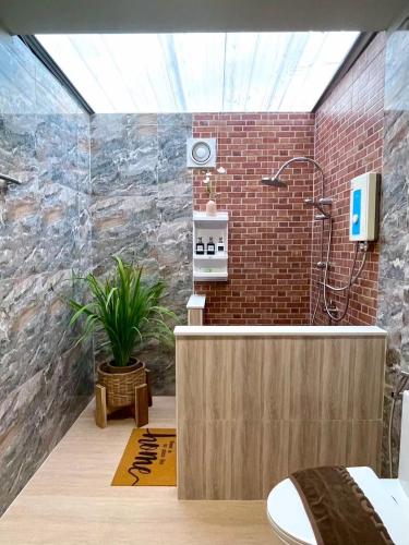 a bathroom with a shower in a brick wall at Himnam Phusang Resort in Ban Pa Sak