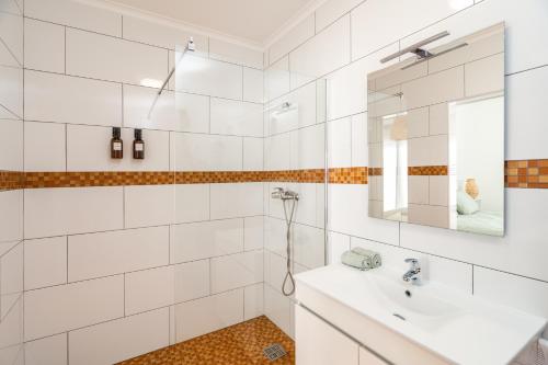 a white bathroom with a sink and a mirror at Spacious house in Olhao in Quelfes