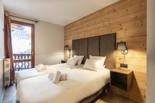 ein Schlafzimmer mit zwei Betten und einem großen Fenster in der Unterkunft Résidence Les Balcons de Belle Plagne in Belle Plagne