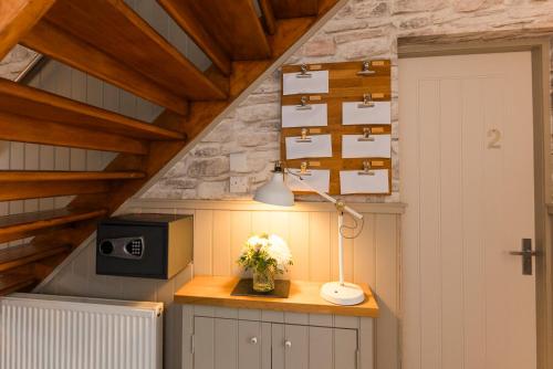 a room with a desk with a lamp and a microwave at The Harbour Guest House in Irvine
