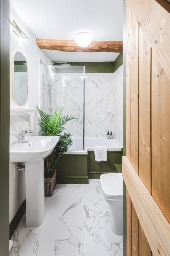 a bathroom with a sink and a toilet and a tub at Crucis Park Estate in Cirencester
