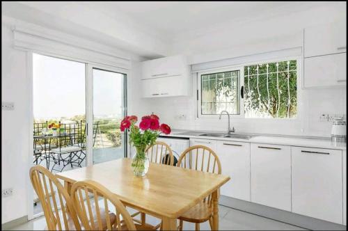 a kitchen with a table with a vase of flowers on it at Amazing Sea View -3 Bed Ground Floor Garden Apartment in Kérynia