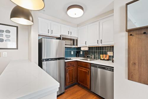 a kitchen with white cabinets and a stainless steel refrigerator at Staybridge Suites North Brunswick by IHG in North Brunswick