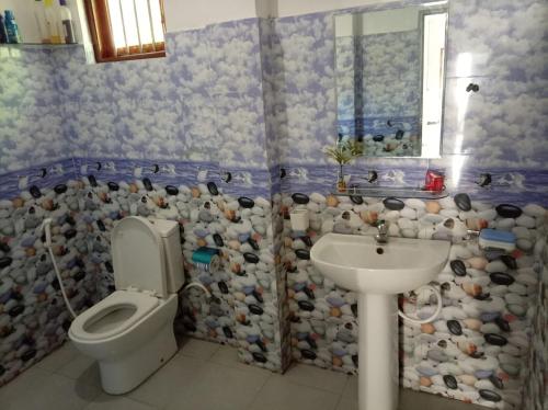 a bathroom with a toilet and a sink at White shell in Sinimodera