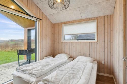 una fila de camas en una habitación con ventana en Spacious Holiday Home On Als Near Little Belt, en Asserballeskov