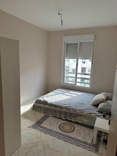 Un dormitorio con una cama y una ventana en Calm & Bright Home, en El Jadida