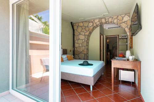 アマンテーアにあるDimore Morelli Amanteaのベッドとテーブルと窓のある寝室