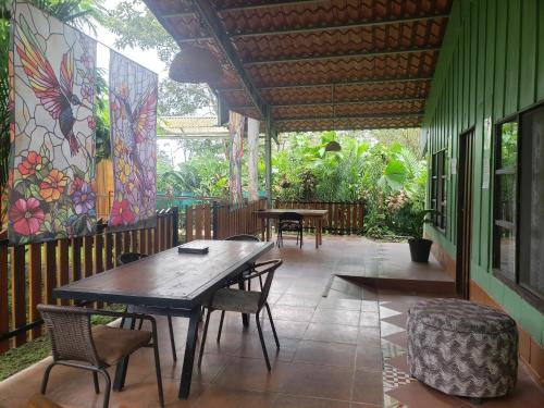a patio with tables and chairs and a mural at Arenal Hostel La Catarata in Fortuna