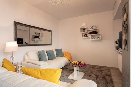 a living room with a white couch and a mirror at Elegant Urban Retreat - City Center in Arad