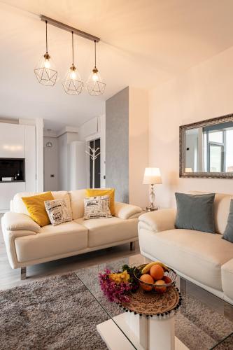 a living room with two couches and a table at Elegant Urban Retreat - City Center in Arad