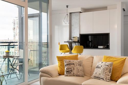 a living room with a couch with yellow pillows at Elegant Urban Retreat - City Center in Arad
