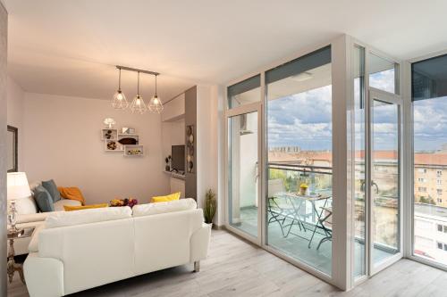 een woonkamer met een witte bank en een balkon bij Elegant Urban Retreat - City Center in Arad