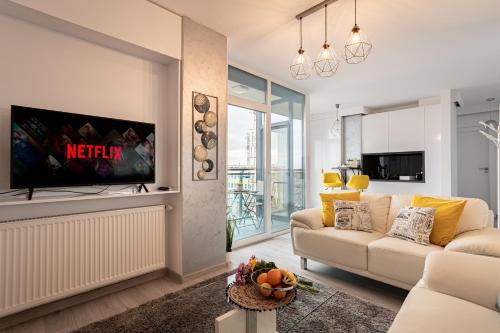 een woonkamer met een bank en een tv bij Elegant Urban Retreat - City Center in Arad