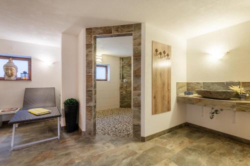 ein Badezimmer mit ebenerdiger Dusche und Waschbecken in der Unterkunft Alpenhof Wängle in Reutte