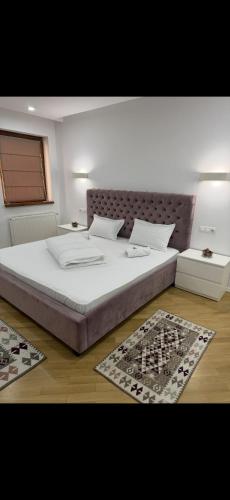 Cama grande en habitación con 2 alfombras en Cozy Central Apartment 2, en Sighetu Marmaţiei