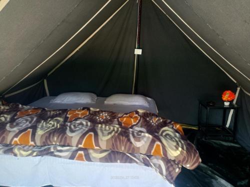 a bedroom with a bed in a tent at Him valley huts and camping in Tehri-Garhwāl