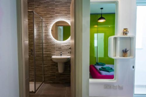 un baño con lavabo y espejo en Elegant 2BR Seaside Stay, Balluta Bay Oasis P2, en Sliema