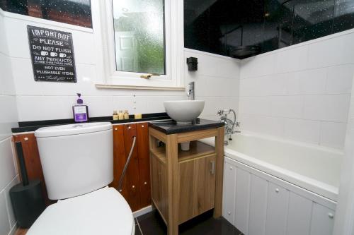 ein Badezimmer mit einer weißen Toilette und einem Waschbecken in der Unterkunft Comfortable 2 Bed Chalet near Snowdonia - Pass the Keys in Caeathro