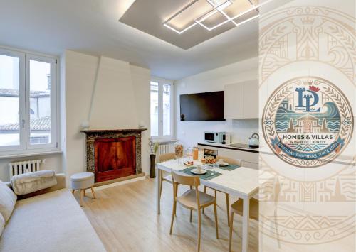 a kitchen and living room with a table and chairs at Apa Dom Downtown Family Apartment DesenzanoLoft Official Partner Homes & Villas by Marriott Bonvoy in Desenzano del Garda