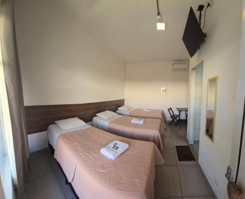 um quarto com três camas e uma mesa em Hotel Itu Shopping em Itu