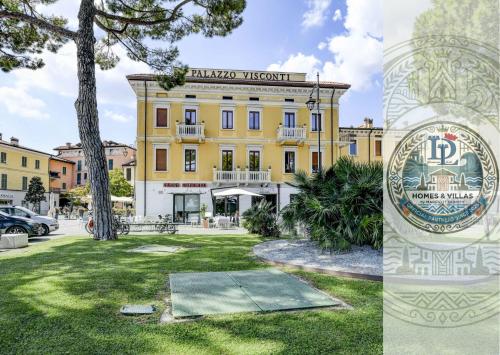 een groot geel gebouw met een bord ervoor bij Palazzo Visconti Luxury Suite DesenzanoLoft Official Partner Homes & Villas by Marriott Bonvoy in Desenzano del Garda